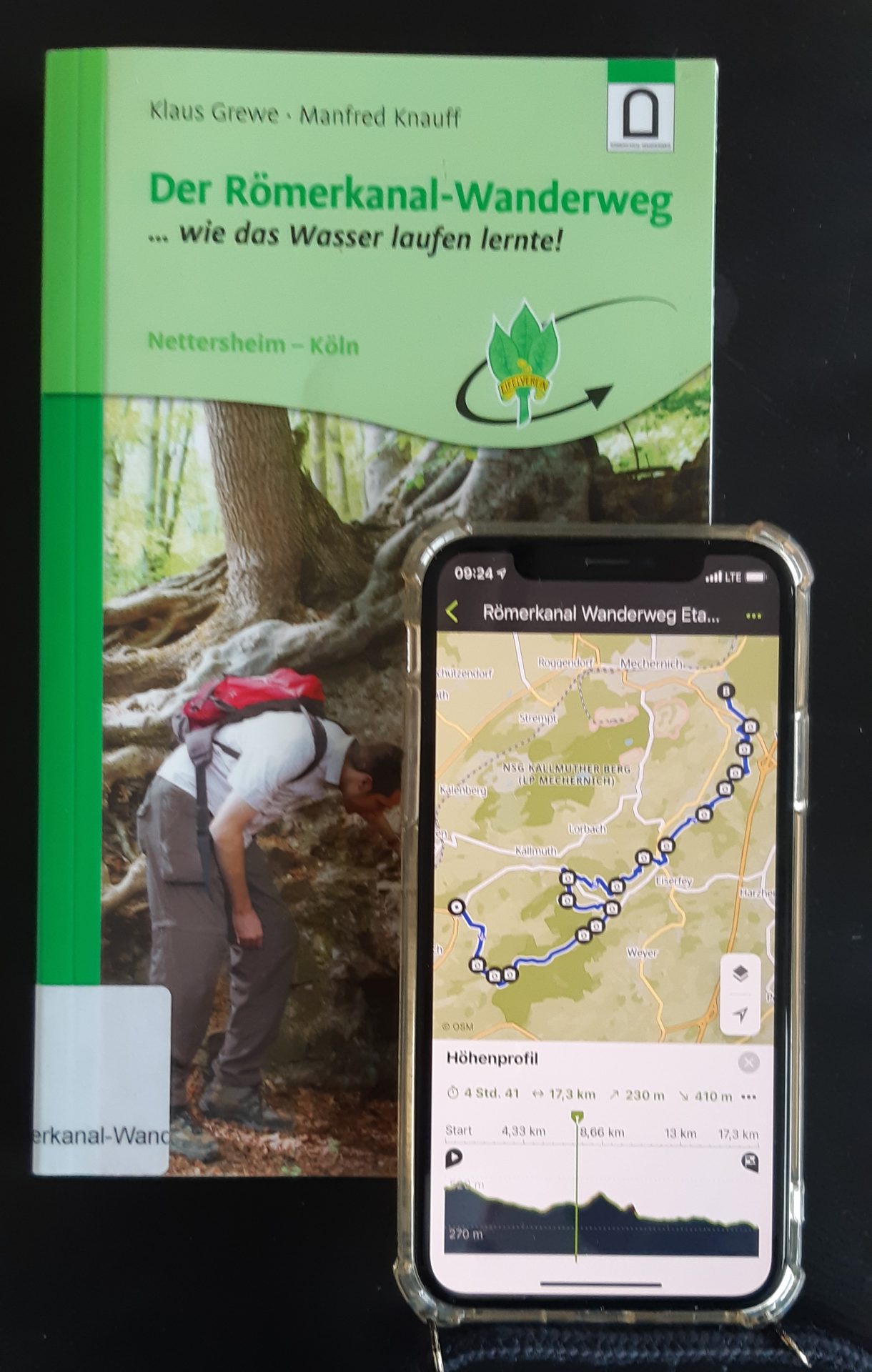 Buch "Der Römerkanal-Wanderweg" und Handy mit geöffneter Komoot-App